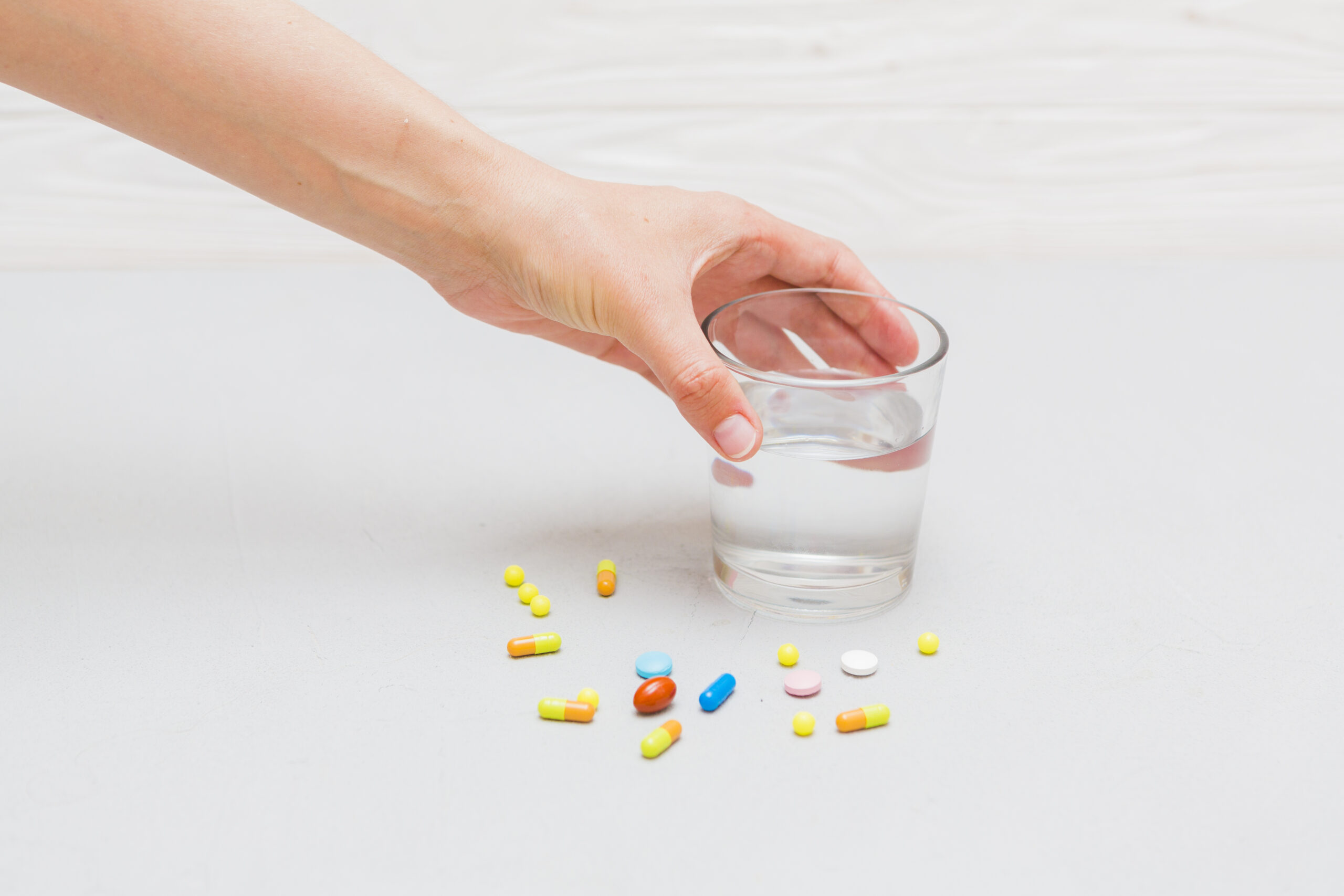 medicine concept with pills hand touching glass scaled