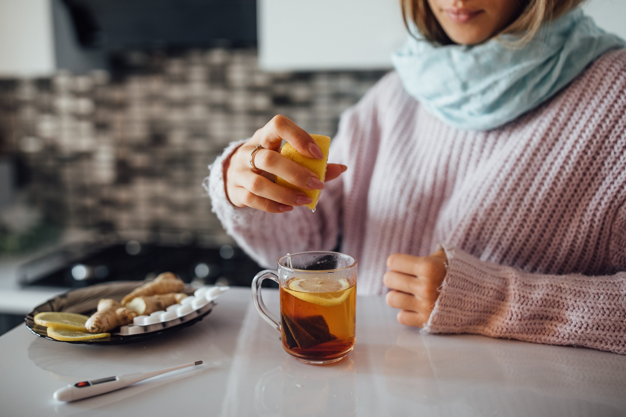 female hands squeezing lemon her tea